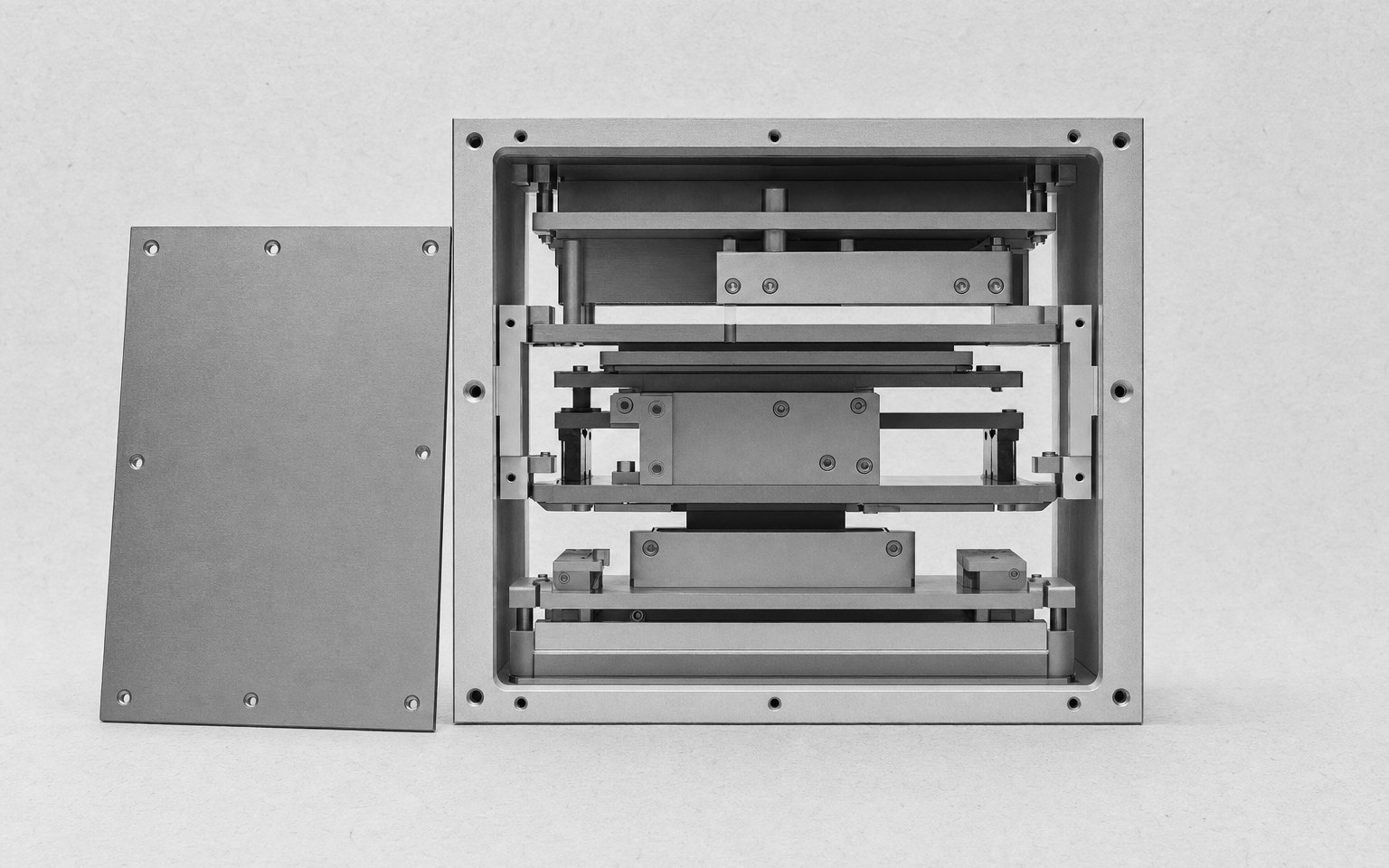 A machined device enclosure with the front panel removed, showing the ordered structure inside.